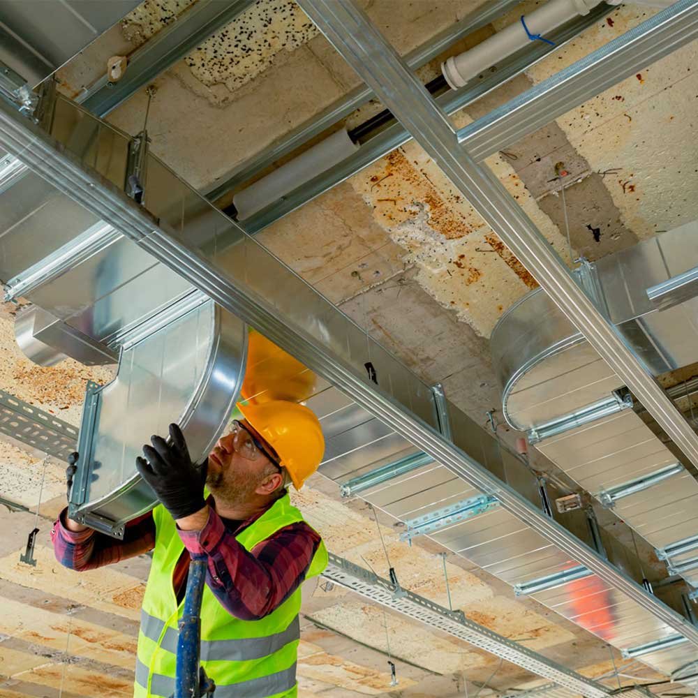 Technician repairing residential ductwork in an attic