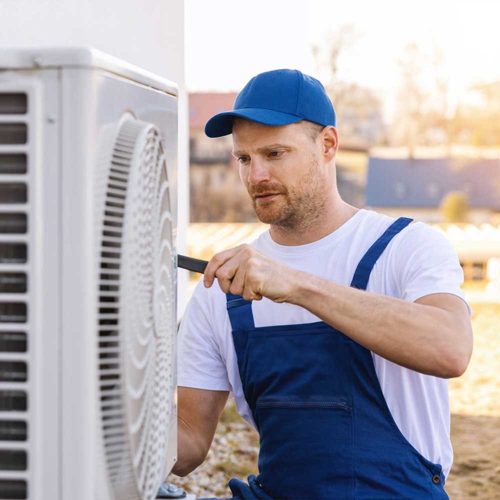 HVAC technician repairing a residential air conditioning unit