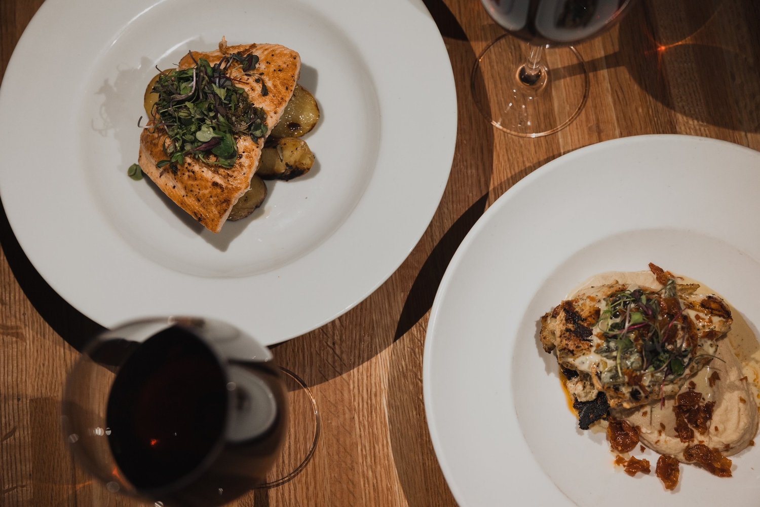 Seared salmon and a pizza on the table at Volanti