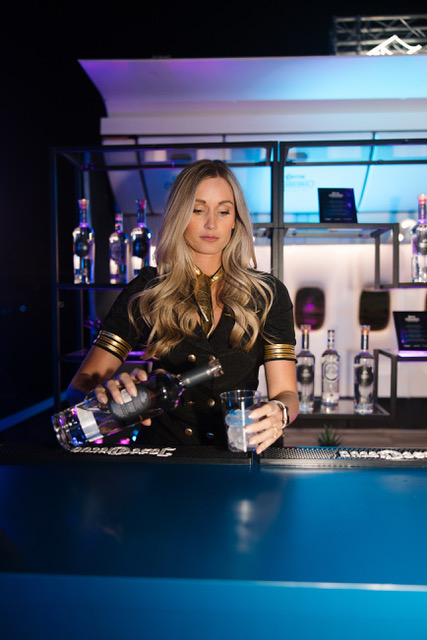 A bartender pouring a cocktail at a hangar event bar