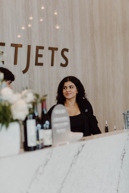 A host welcoming guests at a private aviation front desk